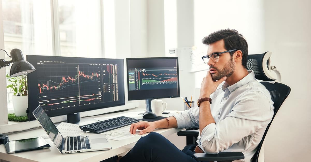 A trader looking at computer screens.